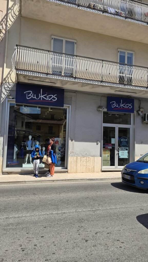 "Escaparate de la tienda Blukids en Italia mostrando ropa de niños colorida y moderna"