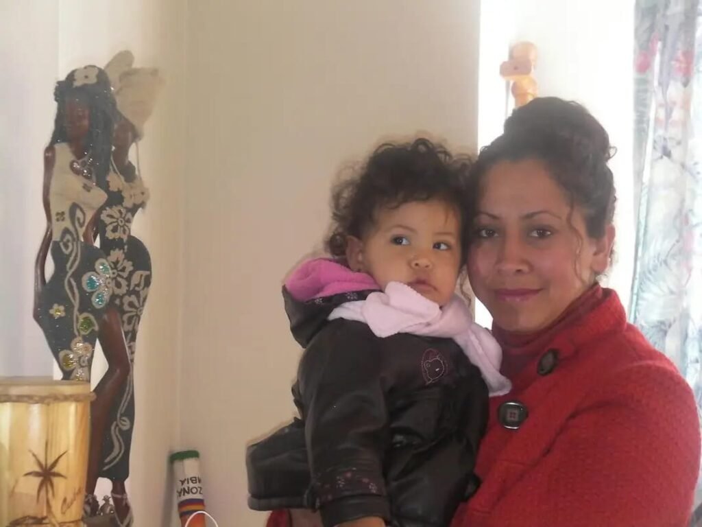 Madre abrazando a su hija pequeña con amor, recordando un momento de luz