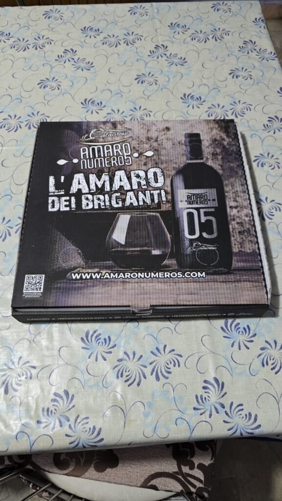 "Caja de pizza de cartón con el logotipo de L'Amaro dei Briganti, mostrando un diseño rústico con tipografía italiana y detalles gráficos inspirados en la tradición calabresa"
